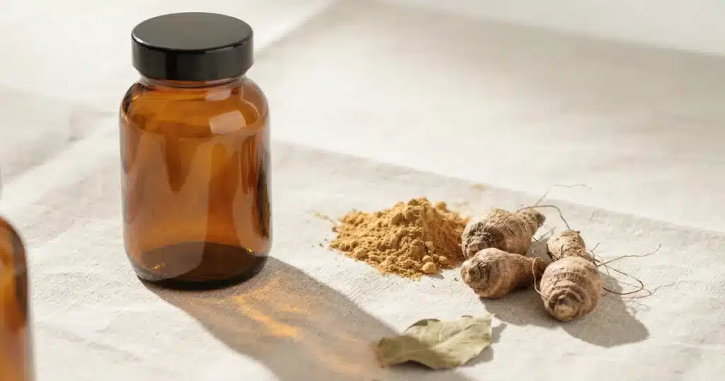 Maca Root for Women: Benefits, Dosage, and Safety by Life Stage Maca root powder in a bowl with a wooden spoon and capsules